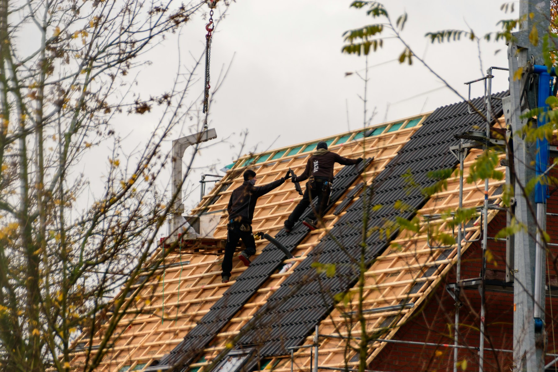 Roofing crew installing materials on a house